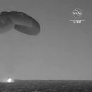 En esta imagen tomada de un video divulgado por la NASA, una cápsula de SpaceX --con paracaídas desplegados para disminuir su velocidad-- cae en el Océano Atlántico el lunes 4 de septiembre de 2023, frente a la costa de Florida. (NASA vía AP)