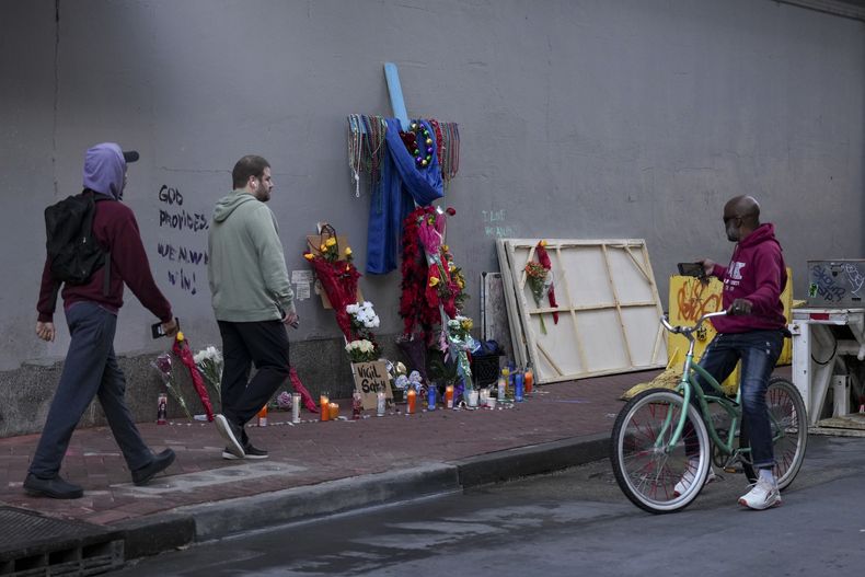 Varias personas observan un sitio de homenaje improvisado para las víctimas de un atropello en Bourbon Street, Nueva Orleans, el viernes 3 de enero de 2025. (AP Foto/George Walker IV)