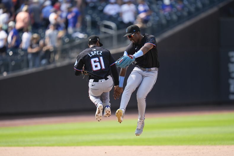 El dominicano Jesús Sánchez de los Marlins de Miami celebra con su compatriota Otto Lopez la victoria ante los Mets de Nueva York el domingo 18 de agosto del 2024. (AP Foto/Seth Wenig)