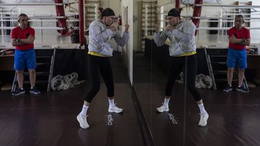 La boxeadora ucraniana Anna Lysenko hace sombra, el jueves 6 de julio de 2023, ante la mirada de su entrenador, Oleksandr Salenko, en el Kiko Boxing Club de Kiev, Ucrania. (AP Foto/Jae C. Hong)