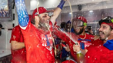 Bryce Harper (izquierda) recibe un baño de champaña durante la celebración de los Filis de Filadelfia tras obtener el pase de comodín al vencer a los Rays de Tampa Bay, el domingo 27 de septiembre de 2026, en Filadelfia. (AP Foto/Laurence Kesterson)