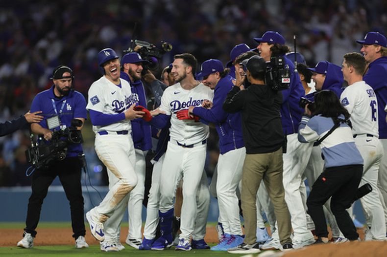 Kyle Tucker, centro, de los Dodgers de Los Ángeles, celebra con sus compañeros de equipo después de dejar tendidos en el terreno a los Marlins de Miami con un sencillo, el lunes 27 de abril de 2026, en Los Ángeles. (AP Foto/Ryan Sun)