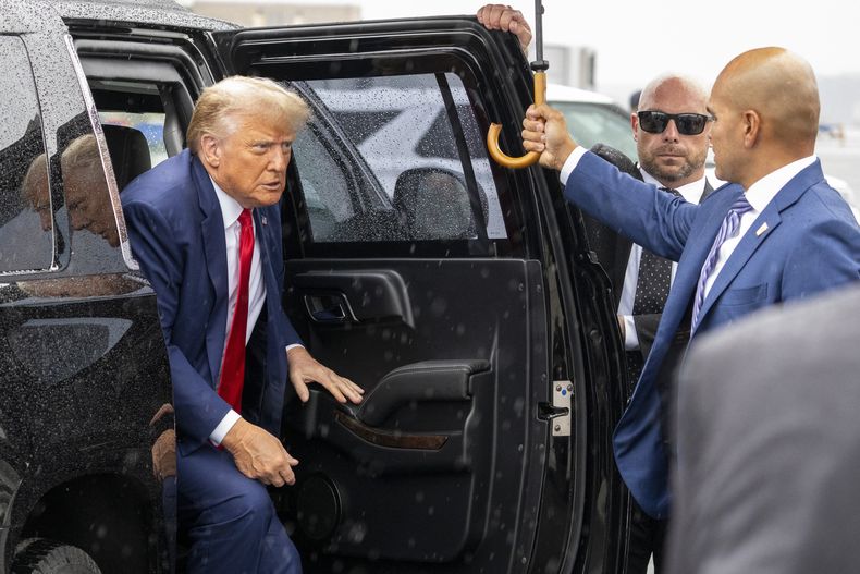 El expresidente Donald Trump baja de su vehículo para abordar su avión en el Aeropuerto Nacional Ronald Reagan de Washington luego de comparecer ante un tribunal que lo juzga por conspiración para revertir la elección de 2020, 3 de agosto de 2020. A su derecha, su valet Walt Nauta. (AP Foto/Alex Brandon)