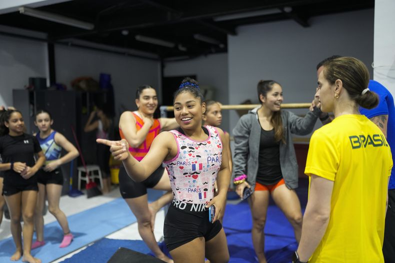La gimnasta panameña Hillary Heron conversa en la capital de su país con varias colegas, antes de un entrenamiento para los Juegos Olímpicos, el sábado 15 de junio de 2024 (AP Foto/Matias Delacroix)
