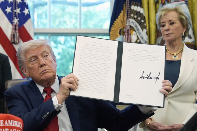 ARCHIVO – El presidente estadounidense Donald Trump sostiene una orden ejecutiva firmada relacionada con las políticas de disciplina escolar, mientras la secretaria de Educación, Linda McMahon, escucha, en el Despacho Oval de la Casa Blanca, el 23 de abril de 2025, en Washington. (AP Foto/Alex Brandon, Archivo)