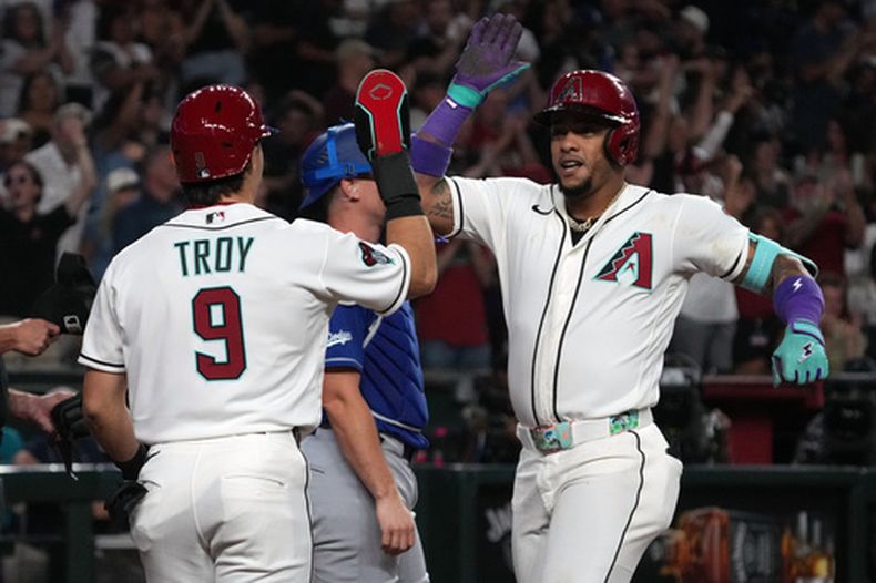 Ketel Marte, de los Diamondbacks de Arizona, celebra con Tommy Troy (9) después de batear un jonrón de dos carreras contra los Dodgers de Los Ángeles en la octava entrada del juego de béisbol de Grandes Ligas, el lunes 1 de junio de 2026, en Phoenix. (AP Foto/Rick Scuteri)