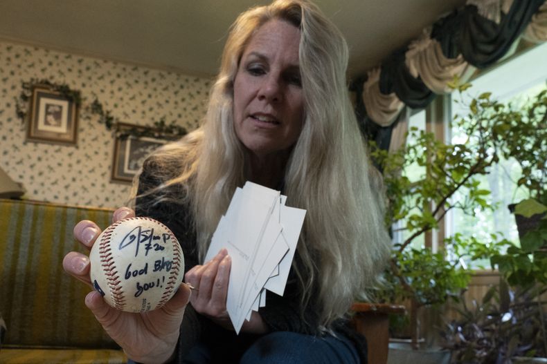 TeriAnn Reynolds sostiene una pelota autografiada por el pelotero colombiano Donovan Solano, el jueves 27 de abril de 2023, en Johnson City, Tennessee (AP Foto/George Walker IV)