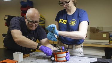 Investigadores de la Junta Nacional de Seguridad en el Transporte examinan las llamadas cajas negras, que registran los datos del vuelo y las voces de cabina, recuperadas tras un choque entre un avión de pasajeros de American Airlines y un helicóptero militar cerca de Washington, D.C, el 30 de enero de 2024. (NTSB vía AP)
