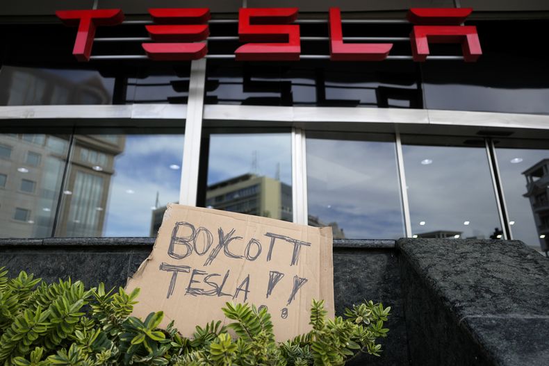 Un cartel es evidencia del descontento hacia Tesla, en un concesionario de esos vehículos en Lisboa el 9 de marzo del 2025. (AP foto/Armando Franca)