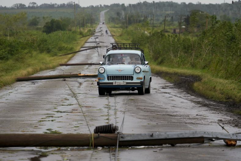 Un vehículo circula por una carretera con postes de luz caídos tras el paso del huracán Rafael, en San Antonio de los Baños, Cuba, el 7 de noviembre de 2024. (AP Foto/Ramón Espinosa)