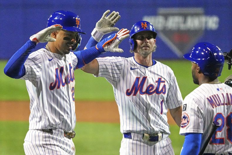 Mark Vientos, izquierda, de los Mets de Nueva York, es felicitado por Jeff McNeil (1), y Cedric Mullins (28) mientras regresa al dugout después de batear un jonrón de tres carreras frente a George Kirby, de los Marineros de Seattle en el partido de béisbol de Grandes Ligas en el Clásico de Pequeñas Ligas el domingo 17 de agosto de 2025 en Bowman Field en Williamsport, Penssylvania. (AP Foto/Gene J. Puskar)