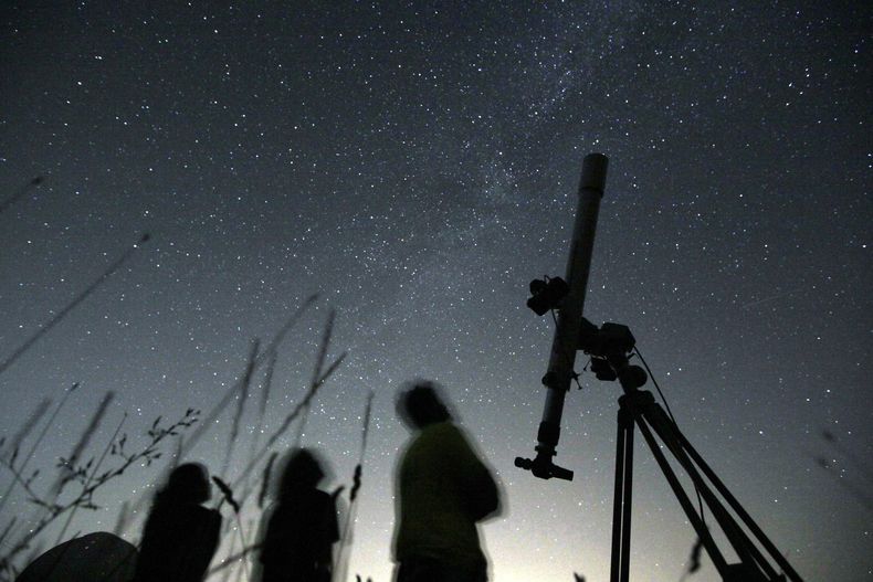 ARCHIVO - Personas miran el cielo desde un observatorio cerca del poblado de Avren, en Bulgaria, el 12 de agosto de 2009. (AP Foto/Petar Petrov, Archivo)
