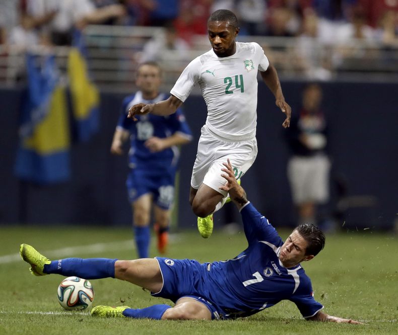 El jugador de la selecci&oacute;n de Costa de Marfil, Jean-Daniel Akpa Akpro, arriba, salta para evitar una entrada en un partido contra Bosnia-Herzegovina el viernes, 30 de mayo de 2014, ,en San Luis.  (AP Photo/Jeff Roberson)