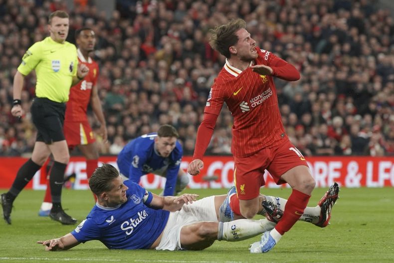 James Tarkowski de Everton comete una falta sobre el argentino Alexis Mac Allister de Liverpool durante un partido de la Liga Premier, disputado el miércoles 2 de abril de 2025 (AP Foto/Ian Hodgson)