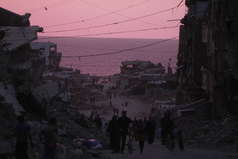 Palestinos caminan entre edificios destruidos en Ciudad de Gaza, el miércoles 3 de junio de 2026. (AP Foto/Jehad Alshrafi)