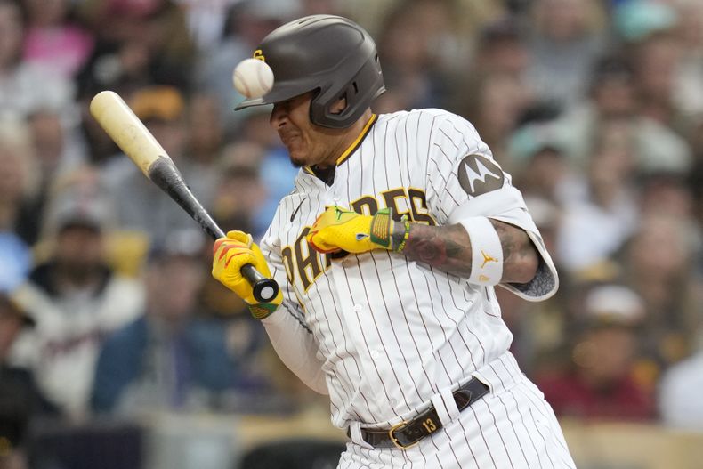 Manny Machado, de los Padres de San Diego, hace un gesto al ser golpeado con un lanzamiento en la segunda entrada del partido contra los Reales de Kansas City, en San Diego, el lunes 15 de mayo de 2023, y en la jugada su compañero Austin Nola anotó desde tercera base. (AP Foto/Gregory Bull)