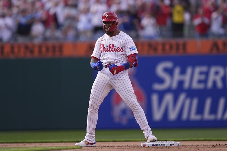 Edmundo Sosa, de los Filis de Filadelfia, reacciona después de batear un doble productor de dos carreras frente a Victor Vodnik, relevist de los Rockies de Colorado, durante la séptima entrada del primer juego de los Filis en su estadio, el lunes 31 de marzo de 2025, en Filadelfia. (AP Foto/Matt Rourke)