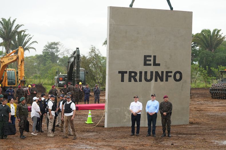 Frente al letrero, el ministro del Interior, Marco Antonio Villeda (izquierda), el presidente guatemalteco Bernardo Arévalo (centro) y el ministro de Defensa, Henry Saenz, posan para las fotos en el lugar donde el gobierno está construyendo una prisión de máxima seguridad llamada El Triunfo, en Morales, al norte de Guatemala, el viernes 27 de marzo de 2026. (AP Foto/Moisés Castillo)