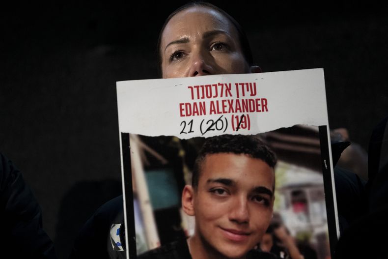 Yael Alexander muestra un cartel de su hijo, Edan, tomado como rehén por milicianos de Hamás el 7 de octubre de 2023, en una marcha semanal de familiares de rehenes retenidos en la Franja de Gaza y sus simpatizantes, en Tel Aviv, Israel, el 22 de febrero de 2025. (AP Foto/Maya Alleruzzo)
