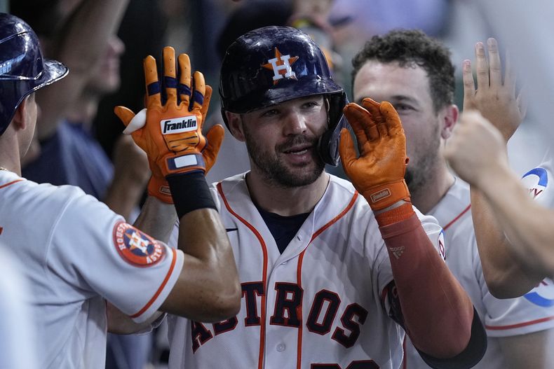 Chas McCormick, de los Astros de Houston, es felicitado en la caseta del equipo después de batear un cuadrangular de dos carreras durante la segunda entrada del juego de béisbol en contra de los Guardianes de Cleveland, el miércoles 2 de agosto de 2023, en Houston. (AP Foto/Kevin M. Cox)