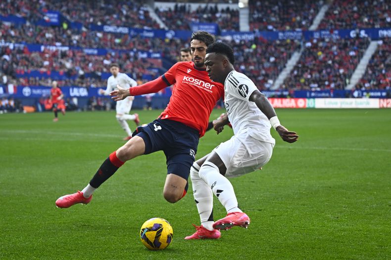 Alejandro Catena del Osasuna pelea por el balón con Vinicius Junior del Real Madrid en el encuentro de la liga española el sábado 15 de febrero del 2025. (AP Foto/Miguel Oses)