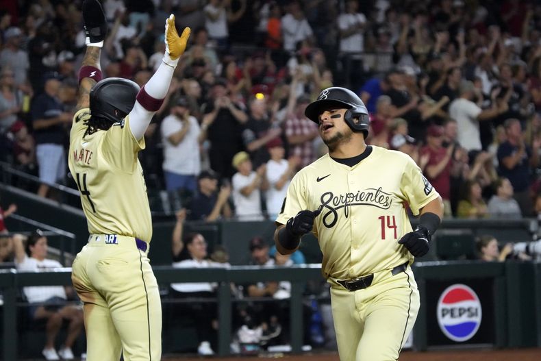 Ketel Marte y Gabriel Moreno de los Diamondbacks de Arizona celebran tras anotar en la séptima entrada ante los Gigantes de San Francisco el martes 4 de junio del 2024. (AP Foto/Rick Scuteri)