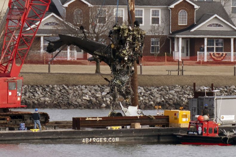 Equipos de rescate retiran una parte de un helicóptero Black Hawk cerca del lugar donde un avión de American Airlines chocó con él sobre el río Potomac, a un costado del Aeropuerto Nacional Ronald Reagan, el jueves 6 de febrero de 2025, en Arlington, Virginia. (AP Foto/José Luis Magaña)
