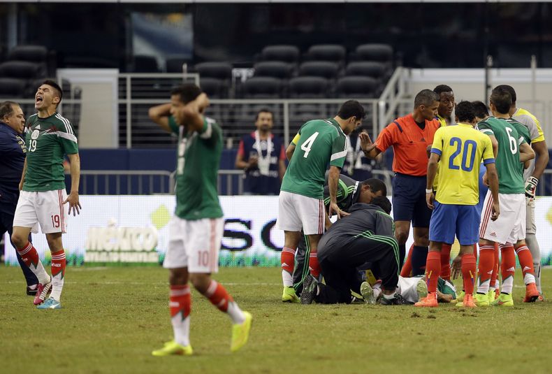 El jugador de M&eacute;xico, Oribe Peralta, izquierda, grita mientras m&eacute;dicos de la selecci&oacute;n atienden a su compa&ntilde;ero Luis Montes tras sufrir una lesi&oacute;n en un amistoso contra Ecuador el s&aacute;bado, 31 de mayo de 2014, en Arl