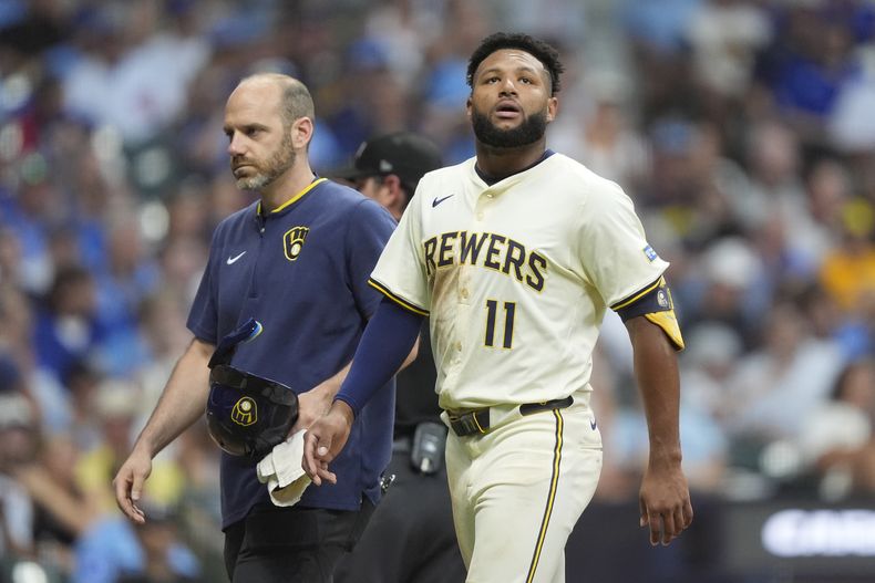 Jackson Chourio (11) de los Cerveceros de Milwaukee mira mientras camina hacia el dugout después de sufrir una lesión durante la quinta entrada de un partido de béisbol contra los Cachorros de Chicago, el martes 29 de julio de 2025, en Milwaukee. (AP Photo/Aaron Gash)