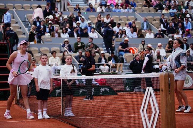 La rusa Mirra Andreeva posa con unos niños mientras que la ucraniana Marta Kostyuk se negó a hacerlo durante el partido de tenis de semifinales en el Abierto de Francia en París, el jueves 4 de junio de 2026. (Foto AP/Christophe Ena)