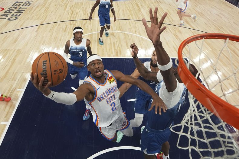 Shai Gilgeous-Alexander, del Thunder de Oklahoma City, salta para encestar frente a Naz Reid, de los Tiñmberwolves de Minnesota, el sábado 20 de enero de 2024 (AP Foto/Abbie Parr)
