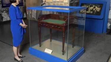 ARCHIVO - Luci Baines Johnson contempla el escritorio en la Biblioteca Presidencial LBJ, 16 de mayo de 2023, sobre el cual el presidente Lyndon B. Johnson firmó la Ley del Derecho al Voto el 6 de agosto de 1965. Preocupadas por el estado de la democracia en medio de la profunda polarización nacional, las entidades que sostienen 13 bibliotecas presidenciales que se remontan a la de Herbert Hoover exhortan a renovar el compromiso con los principios fundamentales del país, como el estado de derecho y el respeto a la diversidad de creencias. (AP Foto/Stephen Spillman, File)