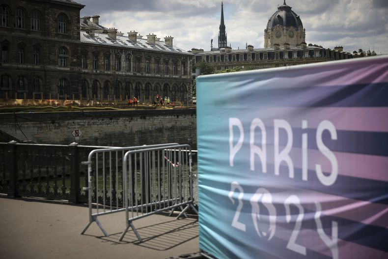 Trabajadores realizan labores a lo largo del río Sena antes de la inauguración de los Juegos Olímpicos, el domingo 21 de julio de 2024, en París. (AP Foto/Thomas Padilla)