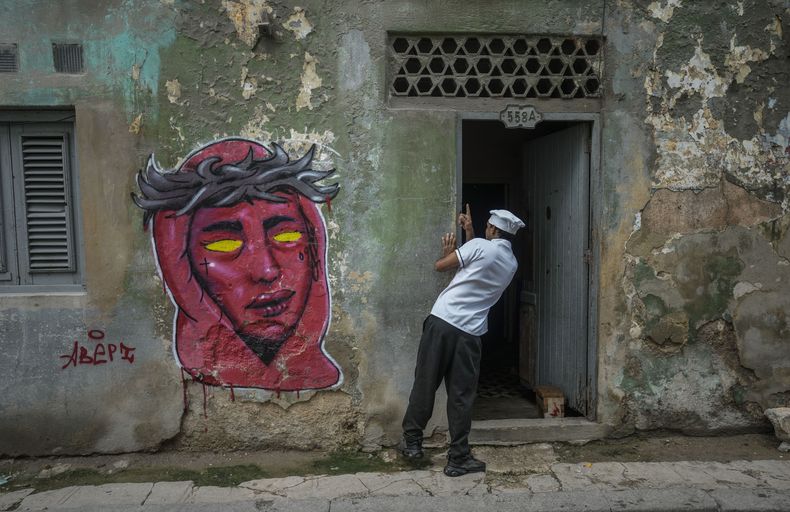 Un cocinero observa a un residente durante un apagón masivo luego de que una importante planta eléctrica falló en La Habana, Cuba, el sábado 19 de octubre de 2024. (Foto AP/Ramón Espinosa)