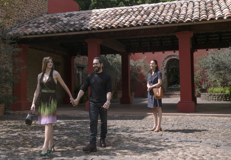 En esta imagen proporcionada por Netflix, Irene Azuela como Teresa Scaglia, Omar Chaparro como Tano Scaglia, y Cassandra Ciangherotti como Mavi Guevara en una escena de Las Viudas de los Jueves. (Camila Jurado/Netflix vía AP)