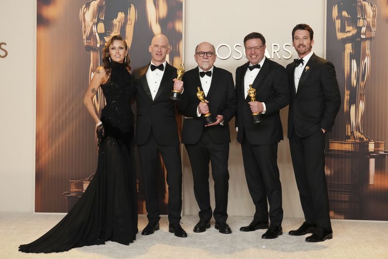 Miley Cyrus y Miles Teller, a la derecha, posan junto a Gareth John, segundo a la izquierda, Richard King y Ron Bartlett, ganadores del Oscar al mejor sonido por Dune: Part Two, en la sala de prensa de los premios el domingo 2 de marzo de 2025 en el Teatro Dolby de Los Ángeles. (Foto, Jordan Strauss/Invision/AP)