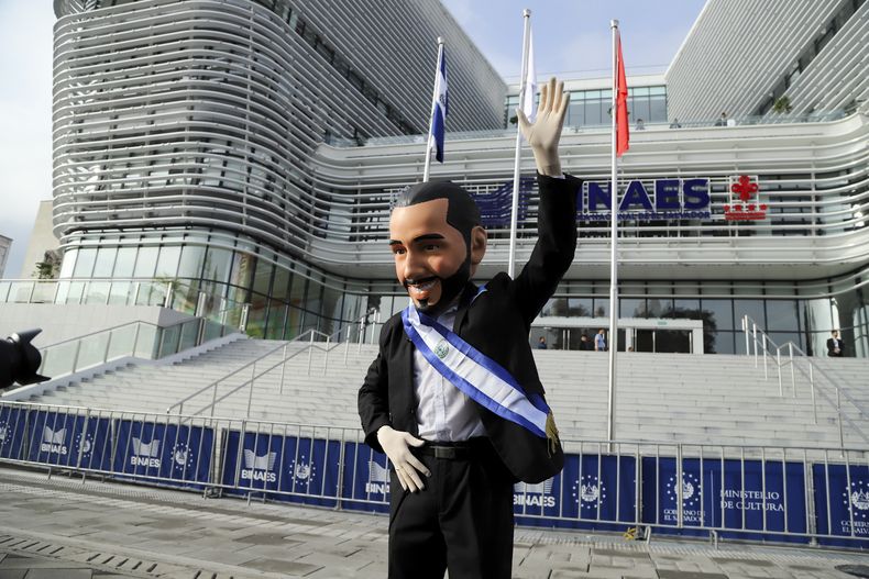 Un partidario del presidente de El Salvador, Nayib Bukele, con una máscara que lo representa, posa para una fotografía afuera de la Biblioteca Nacional antes de su toma de posesión para un segundo mandato en San Salvador, El Salvador, el sábado 1 de junio de 2024. (Foto AP/Salvador Meléndez)