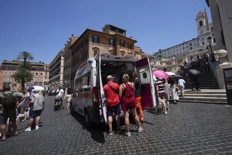 ARCHIVO - Paramédicos atienden a turistas y residentes en una ambulancia cerca de la Plaza de España, en Roma, Italia, el 1 de julio de 2025. (AP Foto/Andrew Medichini)