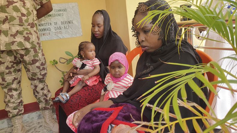 Dos mujeres recientemente liberadas permanecen sentadas con sus bebés en el Cuartel Militar Maimalari, en Maiduguri, Nigeria, el jueves 4 de mayo de 2023. (AP Foto/Jossy Ola)