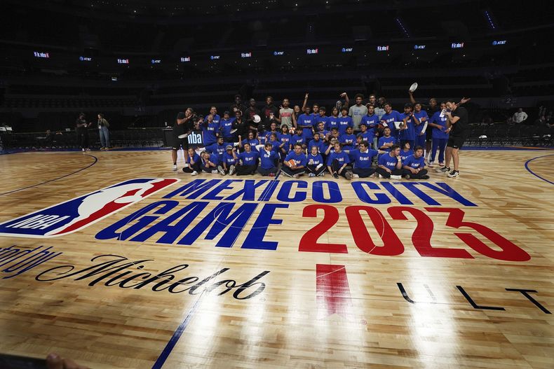Los jugadores del Magic de Orlando y de los Hawks de Atlanta posan junto a niños con síndrome de Down, durante un entrenamiento en la Arena Ciudad de México, el miércoles 8 de noviembre de 2023 (AP Foto/Marco Ugarte)