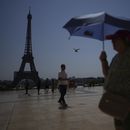 ARCHIVO - Varias personas caminan por la plaza de Trocadero, cerca de la torre Eiffel, en plena ola de calor, el 2 de julio de 2025, en París. (AP Foto/Christophe Ena, archivo)
