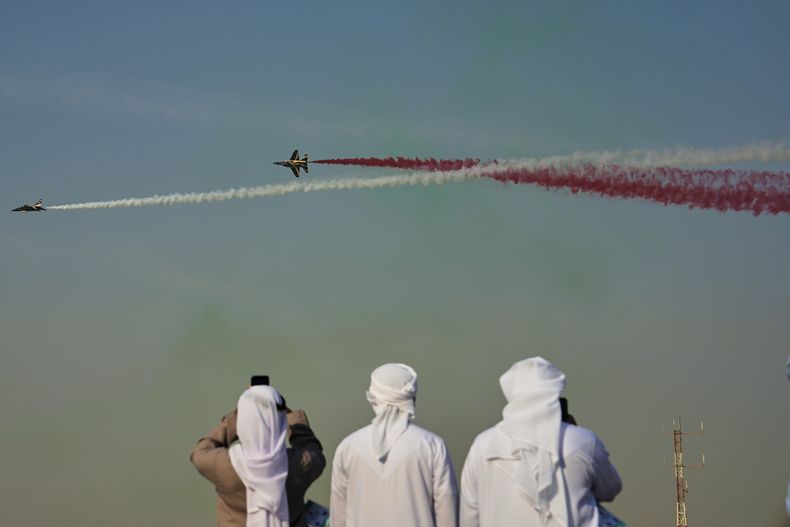 Emiratíes toman fotos de Fursan Al Emarat, el equipo de acrobacias aéreas de la Fuerza Aérea de Emiratos Árabes Unidos, durante el Dubai Air Show, en Dubái, Emiratos Árabes Unidos, el 18 de noviembre de 2025. (AP Foto/Fatima Shbair)