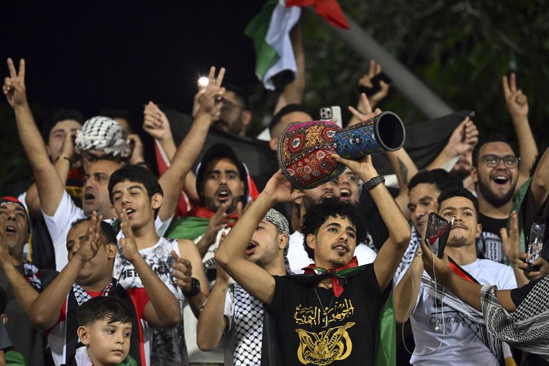 Los aficionados posan para las fotos mientras esperan el inicio de un partido de clasificación para la Copa del Mundo entre la selección palestina de fútbol y Jordania en el estadio Cheras en Kuala Lumpur, Malasia, el martes 10 de septiembre de 2024. (AP Foto/Vivian Lo)