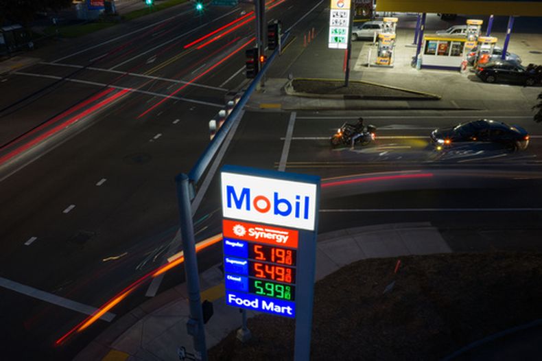 En la imagen, tomada con una baja velocidad de obturador, los autos avanzan frente al letrero de una gasolinería de Mobil el miércoles 29 de abril de 2026, en Portland, Oregon. (AP Foto/Jenny Kane)