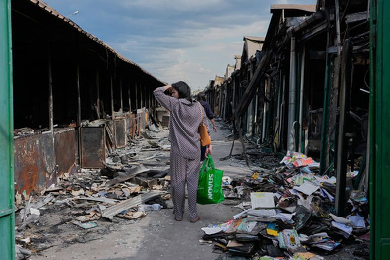 ARCHIVO - Una mujer se lamenta al ver libros calcinados tras un incendio en el mayor mercado de libros del país, provocado por un ataque con misiles rusos, el 19 de agosto de 2026, en Kiev, Ucrania. (AP Foto/Efrem Lukatsky, archivo)