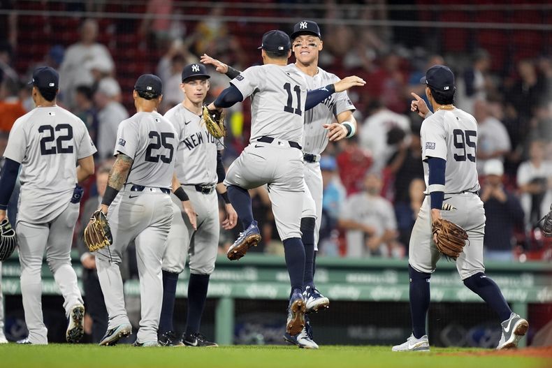 Aaron Judge, de los Yankees de Nueva York, centro-derecha, celebra con Anthony Volpe (11) y sus compañeros de equipo después de derrotar a los Medias Rojas de Boston en un juego de béisbol, el domingo 28 de julio de 2024, en Boston. (AP Foto/Michael Dwyer)