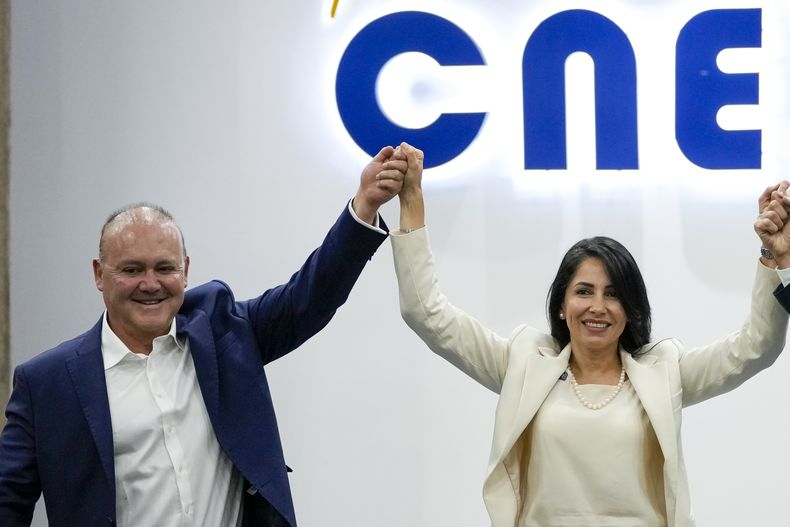 La candidata presidencial de Revolución Ciudadana, Luisa González, y su compañero de fórmula, Diego Borja, levantan los brazos al unísono después de registrar su nómina para las próximas elecciones, en Quito, Ecuador, el sábado 28 de septiembre de 2024. (Foto AP/Dolores Ochoa)