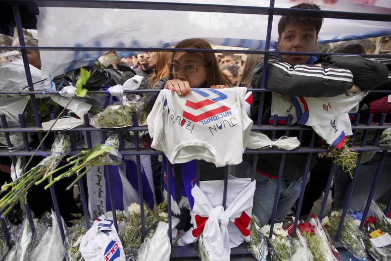 Personas observan el velatorio de Juan Izquierdo en Montevideo, el jueves 29 de agosto de 2024. El jugador del club uruguayo Nacional falleció tras sufrir una arritmia en un partido de la Copa Libertadores en Sao Paulo. (AP Foto/ Matilde Campodónico)