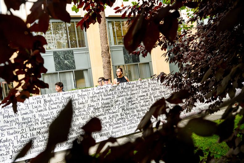 Lennon Torres de Heat Initiative sostiene un cartel con los nombres de jóvenes que, según defensores, murieron debido a las redes sociales, fuera del edificio federal y tribunal Ronald V. Dellums, el martes 18 de agosto de 2026, en Oakland, California. (AP Foto/Noah Berger)