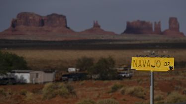 ARCHIVO - Un cartel de Navajo Drive, frente a viviendas y otras estructuras en Oljato-Monument Valley, Utah, en el territorio indígena semiautónomo Navajo Nation, el 30 de abril de 2020. (AP Foto/Carolyn Kaster, archivo)